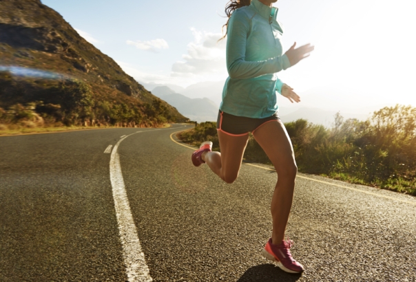 Cropped shot of a young woman jogging on a country road